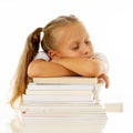 Exhausted schoolgirl falling asleep on her books after studying too much