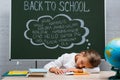 Schoolgirl sleeping at desk near globe