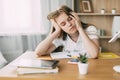 The exhausted schoolgirl is tired of doing homework, from studying at home, preparing for exams. Home education, home Royalty Free Stock Photo