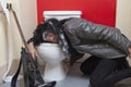 Exhausted senior male guitarist sleeping in toilet