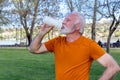 Senior man is catching his breath after exercising in the public city park.