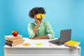 Exhausted student. Black teen guy with painted eyes on stickers sitting at desk and sleeping in front of laptop