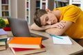 Exhausted student sleeping on workplace in front of laptop Royalty Free Stock Photo