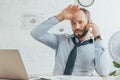 exhausted sweaty businessman talking on smartphone and working