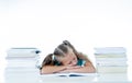 Exhausted sweet cute blonde girl sleeping on a pile of schoolbooks after being studying hard isolated on a withe background in too Royalty Free Stock Photo