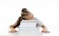 Exhausted sweet cute blonde girl sleeping on a pile of schoolbooks after being studying hard isolated on a withe background in too Royalty Free Stock Photo