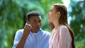 Exhausted teen girl listening Afro-American boyfriend arguing, difficulties Royalty Free Stock Photo