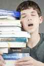 Exhausted Teen Holds Stack Of Textbooks