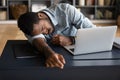 Exhausted tired African American businessman lying on desk and sleeping Royalty Free Stock Photo