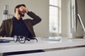 Exhausted tired worker at the workplace covered his face with his hands in the office Royalty Free Stock Photo