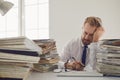 Exhausted tired worker at the workplace covered his face with his hands in the office Royalty Free Stock Photo