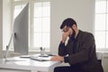 Exhausted tired worker at the workplace covered his face with his hands in the office Royalty Free Stock Photo