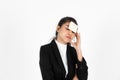 Exhausted tired young Asian business woman in formal wear with adhesive note on her forehead over white isolated background Royalty Free Stock Photo