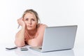 Exhausted unhappy blond girl leaning on her white sparse desk