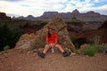 Exhausted woman backpacker resting on the New Hance Trail in the Grand Canyon.