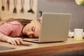 Exhausted woman with box-braids sleeps on laptop