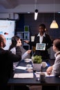 Exhausted workaholic african american showing financial graphs using tablet overworking in company office Royalty Free Stock Photo