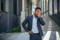 Exhausted young African American business man office worker stand outdoors. stressed overworked black male with a headache Royalty Free Stock Photo