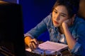 Exhausted young Asian creative feeling sleepy, looking on pc. Stratagem. Royalty Free Stock Photo
