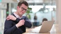 Exhausted Young Businessman with Laptop having Shoulder Pain