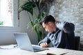 Exhausted young Caucasian male worker sit at desk massage neck suffer from strain spasm muscles. Tired unwell man overwhelmed with Royalty Free Stock Photo