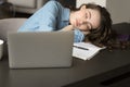 Exhausted young freelance professional girl falling asleep at work desk Royalty Free Stock Photo