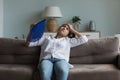 Exhausted young Indian girl feeling hot, resting on couch Royalty Free Stock Photo