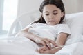 Exhausted young lady examining injected drop counter in bed