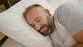 Exhausted young man enjoying cozy comfort, sleeping deeply on a soft bed in a relaxed morning scene at home bedroom Royalty Free Stock Photo