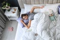 Exhausted young mother sleeping in bed at home, above view Royalty Free Stock Photo