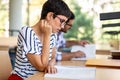 Exhausted young female studying and preparing for exam in college library. Education people concept Royalty Free Stock Photo