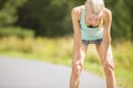 Exhausted young woman catching her breath after a long run