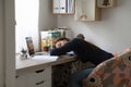 Exhausted young woman freelancer napping by desk after difficult workday