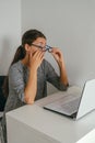 Exhausted young woman holding glasses and touching her eyes, overworking and eye fatigue from computer concept Royalty Free Stock Photo