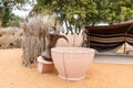 An exhibit in the form of a large ancient stone cup and a copper coffee pot in the yard of the Heritable village Abu Dhabi museum