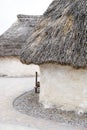 Exhibition neolithic house at Stonehenge, Salisbury, Wiltshire, England with hazel thatched roof and straw hay daubed walls Royalty Free Stock Photo