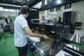 Exhibitor checking modern grill presented on stand. Exhibition