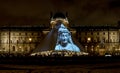 Exhibits of Louvre collection displayed on a glass pyramid entrance in the evening, Paris