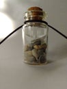 A paper boat in a bottle on shells on a white background.