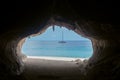 Exit from the cave overlooking beautiful sea and boat at Cala Luna beach Royalty Free Stock Photo