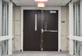 Exit double doors at the end of a carpeted office corridor. Royalty Free Stock Photo