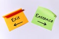 Exit and Entrance written on sticky notes with arrows, illustrating the opposing concepts Royalty Free Stock Photo
