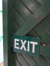 Exit sign attached to green door.