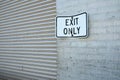 Exit Only sign next to a corrugated steel door