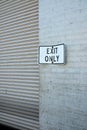 Exit Only sign next to a corrugated steel door