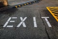 EXIT sign stenciled on ground in parking lot