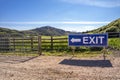Exit sign on wooden fence of a farm and camping site Royalty Free Stock Photo