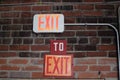 Exit Signs on Red Bricked Wall Royalty Free Stock Photo