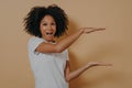 Exited Afro American beautiful young woman with black curly hair showing with hands example of size