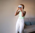 Exited laughing black skin young beautiful woman using VR glasses headset